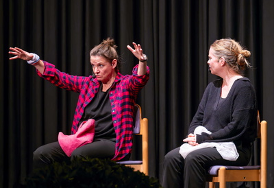 Zwei Frauen sitzen auf Stühlen auf der Bühne
